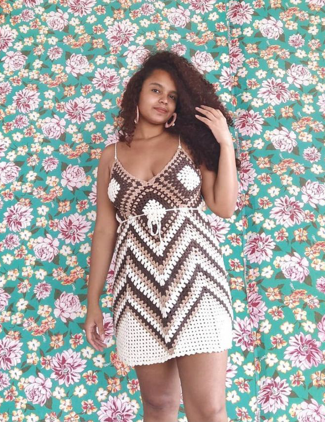 Erika wearing a handmade crochet dress against a floral background
